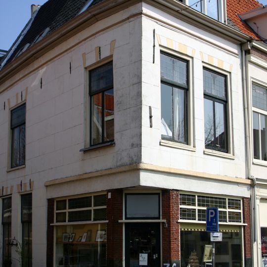 Pand met gepleisterde lijstgevel, moderne onderpui