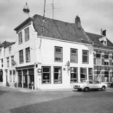 Apart genummerde ingang in gepleisterde zijgevel van hoekhuis vlasmarkt