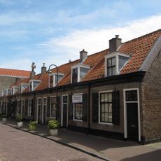 Rij van acht arbeiderswoningen in ambachtelijk-traditionele bouwtrant