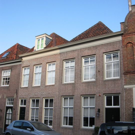 Huis onder schilddak en met lijstgevel, boven met zesdelige schuiframen. Met eigen stoep