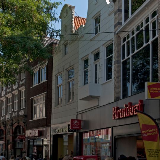 Pand met gepleisterde halsgevel, gebeeldhouwde vleugelstukken en wapensteentje in de top