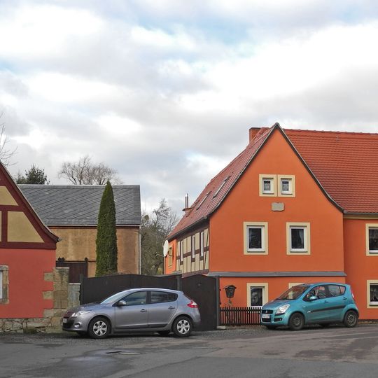 Dreiseithof mit Wohnstallhaus und rückwärtiger Anbau, Scheune und Seitengebäude, dazu ein Torpfeiler der Hofzufahrt Hauptstraße 9