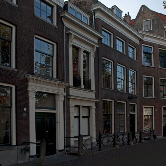 Een pandje met bakstenen lijstgevel met stucdecoratie. Stoephek