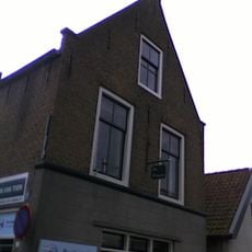 Huis met verdieping en zadeldak tussen puntgevels met vlechtingen