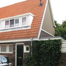 Blok met 8 keukenwoningen, zo genoemd vanwege destijds nieuwe plaatsing van keuken aan de voorzijde, aan de zijkant een houten topgevel, bouwstijl Amsterdamse School.