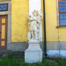 Socha svatého Floriána vpravo u severního portálu kostela Nanebevzetí v Chlumu u Třeboně