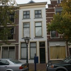 Pand met gebosseerde witgepleisterde lijstgevel