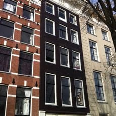 Pand met gevel onder zware versierde lijst met een hoekconsole