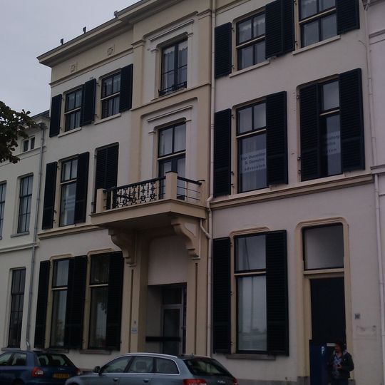 Statig herenhuis met schilddak en gepleisterde lijstgevel met stucwerk en balcon