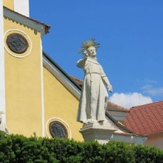 Socha světce uprostřed na terase kostela Nanebevzetí v Chlumu u Třeboně