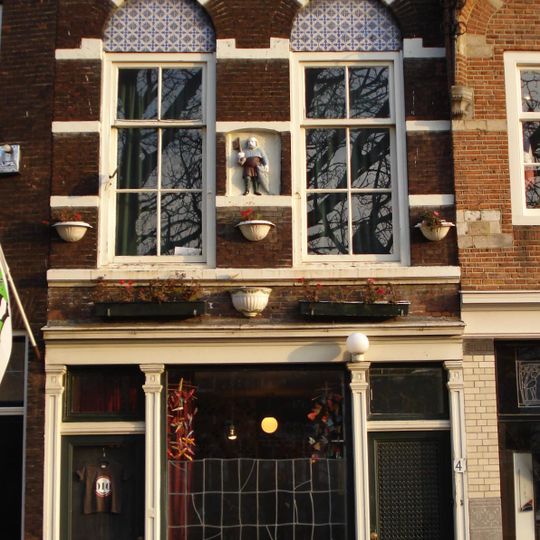 Pand met tot lijstgevel gewijzigde, met natuurstenen banden versierde oorspronkelijke trapgevel. Gevelsteen met afbeelding van St. Petrus