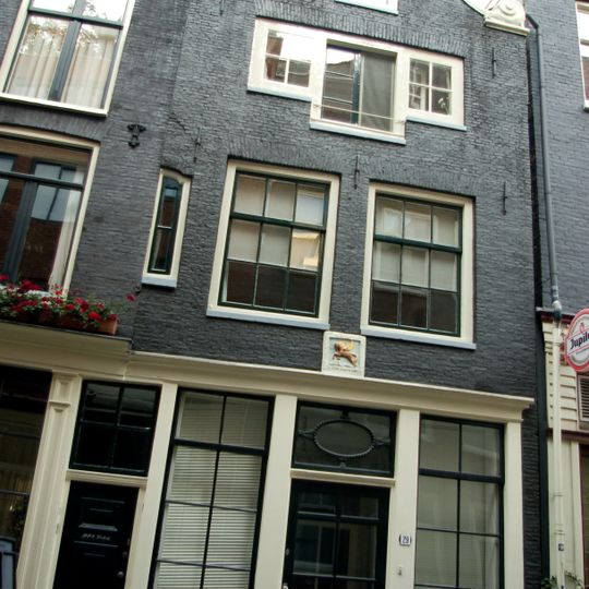 Huis met gevel die in de top van de klokvormige bekroning met rollagen een oude gevelsteen bevat