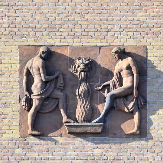 Relief sculpture with man, woman, flow of water, and wash basin