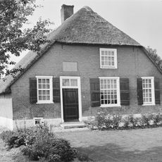 Boerderij. Het woongedeelte heeft een met riet gedekt wolfdak. Vensters met luiken en 25-, 15- en 12 ruitsramen