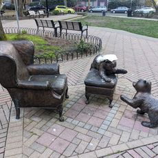 Three-piece bronze sculpture of two bear cubs at play on an ottoman and a chair