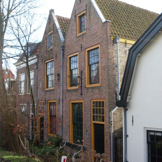 Pand met gepleisterde gevel met rechte kroonlijst en delen van een uithangteken