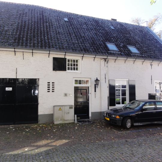 Huis met witte topgevel met vlechtingen