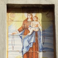 Ceramic panel of Our Lady of the Rosary at 51 Benlliure street