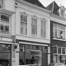 Pand met gepleisterde lijstgevel en jongere winkelpui