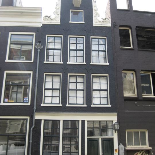 Oud huis waarvoor een nieuwe gevel, waarop de oude hals