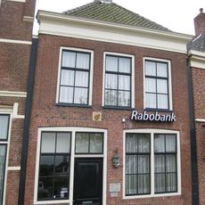 Eenvoudig pand met tot lijstgevel gewijzigde voorgevel en achtertopgevel onder zadeldak