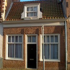 Hoogst eenvoudig pandje zonder verdieping onder dwarskap met kapel