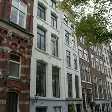 Pand met gepleisterde gevel met vensteromlijstingen en rechte lijst