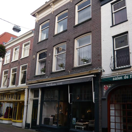 Pand met rechte kroonlijst, onder zadeldak. Beneden verbouwd