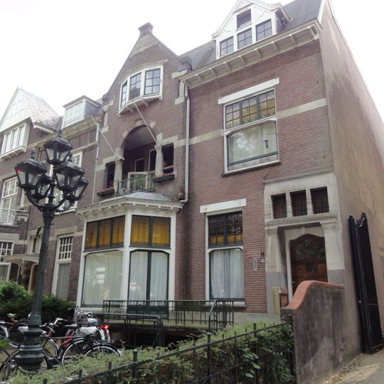 Half-vrijstaand herenhuis met aangebouwde berging en oorspronkelijk smeedijzeren hekwerk rond de voortuin