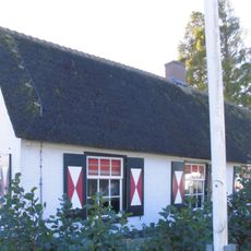 Lage gepleisterde woning, met riet gedekt