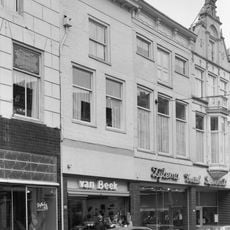 Pand met geverfde gevel en jongere winkelpui