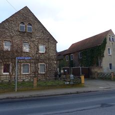Wohnstallhaus eines Dreiseithofes, mit Hofmauer und Toreinfahrt Berbisdorfer Hauptstraße 10