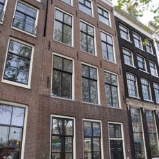 Pand met gevel onder rechte lijst, met snijramen in de houten pui