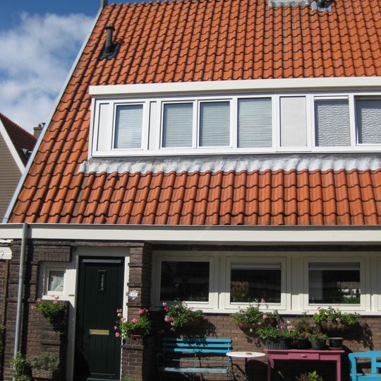 Blok met 8 keukenwoningen, zo genoemd vanwege destijds nieuwe plaatsing van keuken aan de voorzijde, aan de zijkant een houten topgevel, bouwstijl Amsterdamse School.