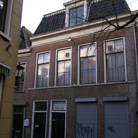 Vier traveeën breed pand met zesruitsvensters en geblokte kroonlijst