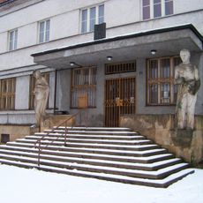 Sochy u vchodu do bývalé spořitelny v Lomnici nad Popelkou