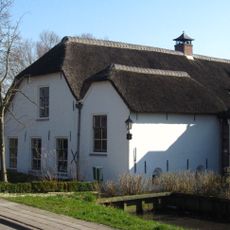 Boerderij, gepleisterd. Rieten wolfdak, vensters met zesruitsschuiframen
