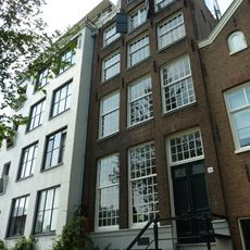 Pand met halsgevel met volutenafdekking en ornament om de hijsbalk