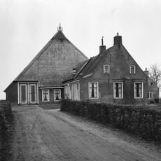 Boerderij met drie zesruitsvensters breed voorhuis onder zadeldak tegen topgevel