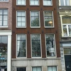 Pand met gevel onder rechte lijst met hardstenen pui, gesneden deur en vier stoeppalen