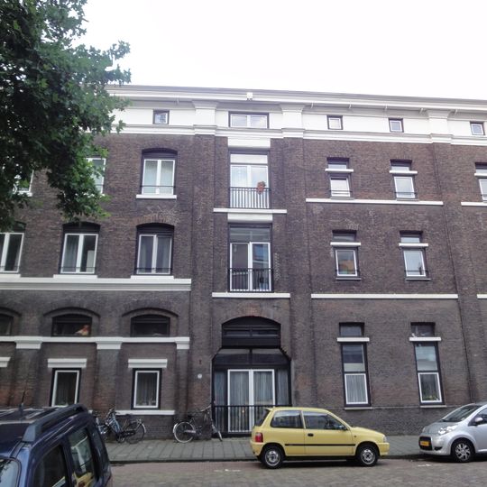 Onderdeel van een reeks pakhuizen. Lijstgevel met getoogde vensters en cordonlijsten