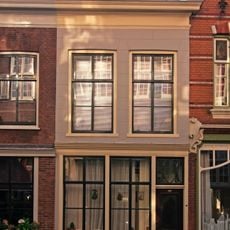 Pand met eenvoudige gepleisterde lijstgevel voor pand van parterre en verdieping