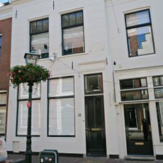 Gepleisterde lijstgevel voor huis van parterre en verdieping onder schilddak