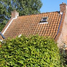 Visserswoning onder zadeldak tussen puntgevels met vlechtingen en achtruitsvensters in bepleisterde voorgevel