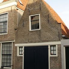 Gerestaureerd pakhuisje met puntgevel, waarin vlechtingen