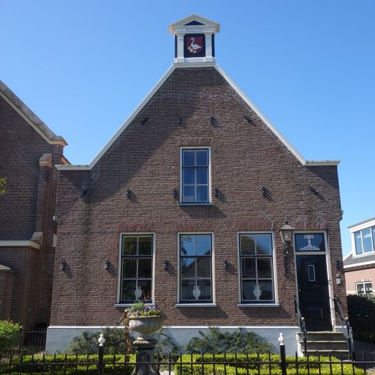 Pand met zolderverdieping, op hoge plint onder met pannen gedekt zadeldak