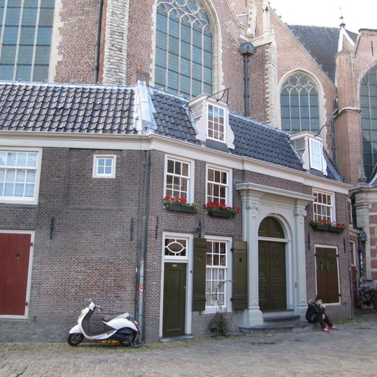 Huis, tegen de Oude kerk aangebouwd, met gepleisterde voorgevel een empire deurpartij