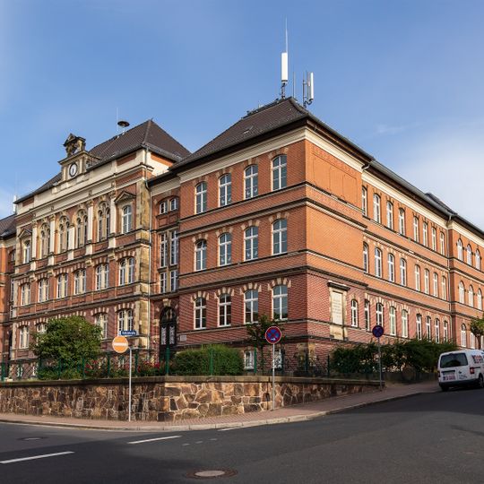 Schule mit Turnhalle und Stützmauer des Vorplatzes sowie Brunnenhaus auf dem Schulhof Schulstraße 19
