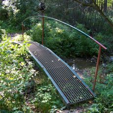 Lávka červeně značené trasy přes potok od rybníka Plocko