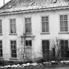 Landhuis met verdieping en pannen schilddak, geheel gepleisterd